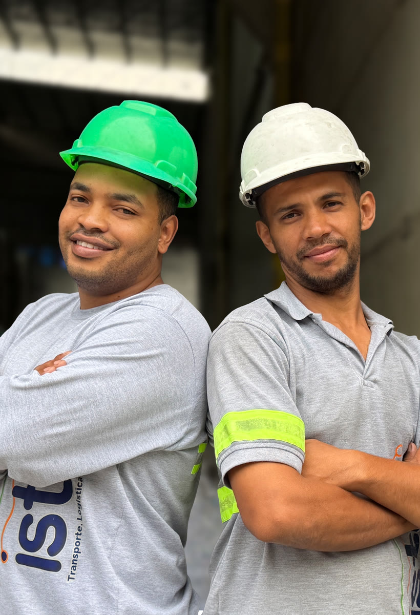 Dos operarios de ISTHO con casco y camiseta corporativa en el muelle de la bodega