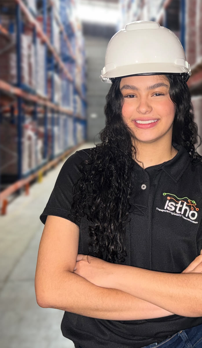 Operaria de ISTHO con casco en un pasillo de estanterías de la bodega